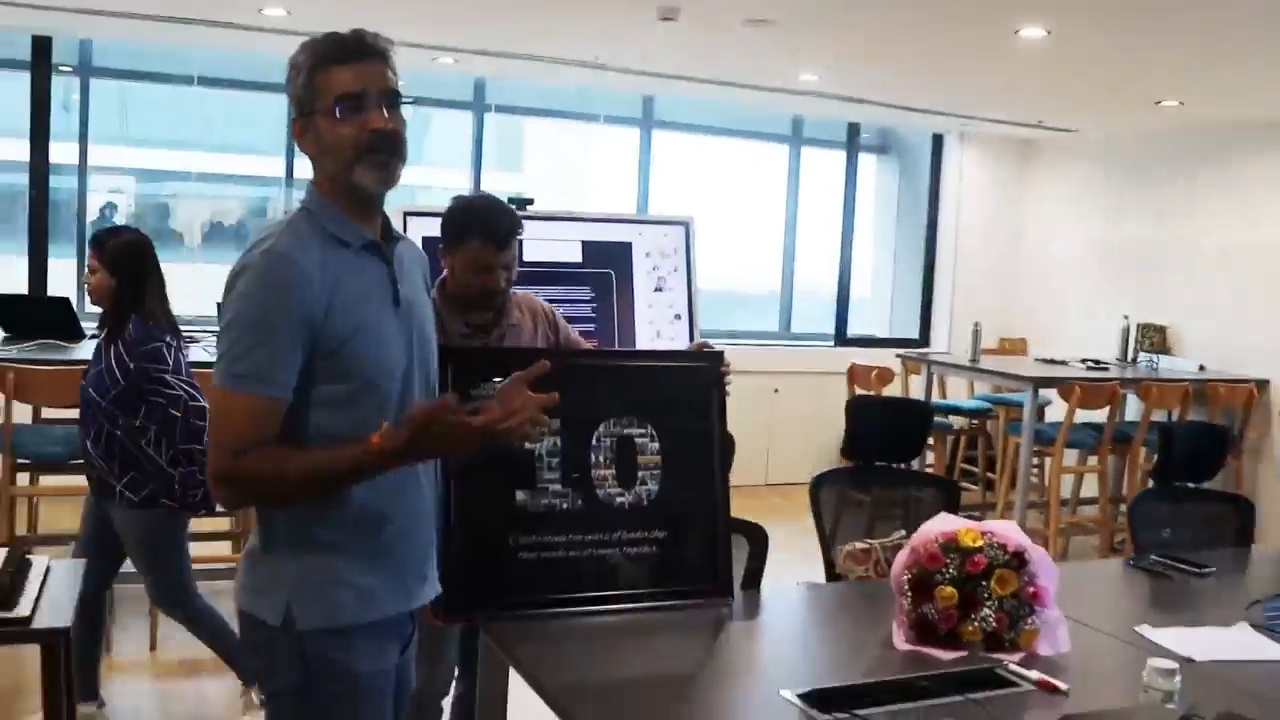 Kapil Godani holds a framed ten-year tribute during NewVision’s office celebration.