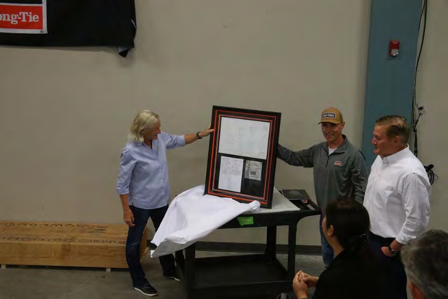 Karen Colonias and David Huerta with her framed engineering drawing and patent at the laboratory dedication