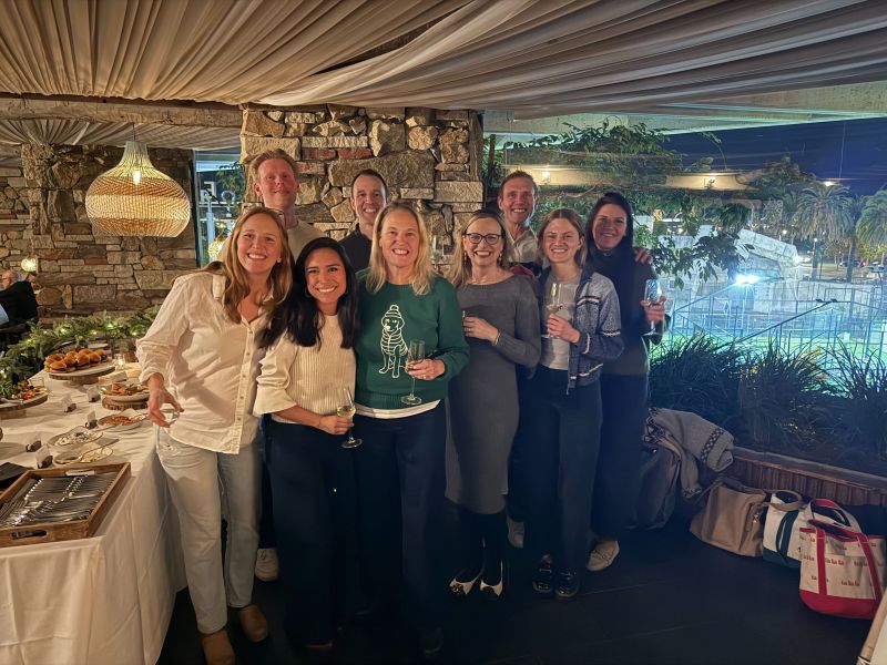 Kari O'Rourke, in a green sweater at center, with members of Brightline's distributed team at an in-person gathering