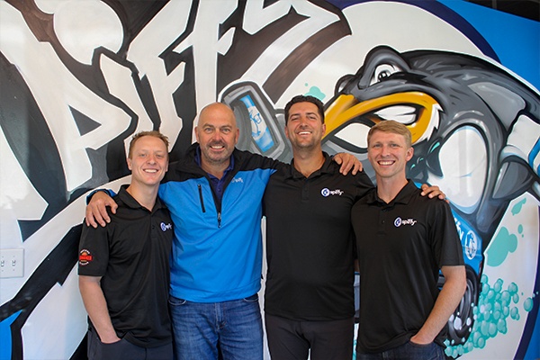 Josh Tillery, Karl Murphy, Harrison Collins and Adam Major together in front of a painted Spiffy wall