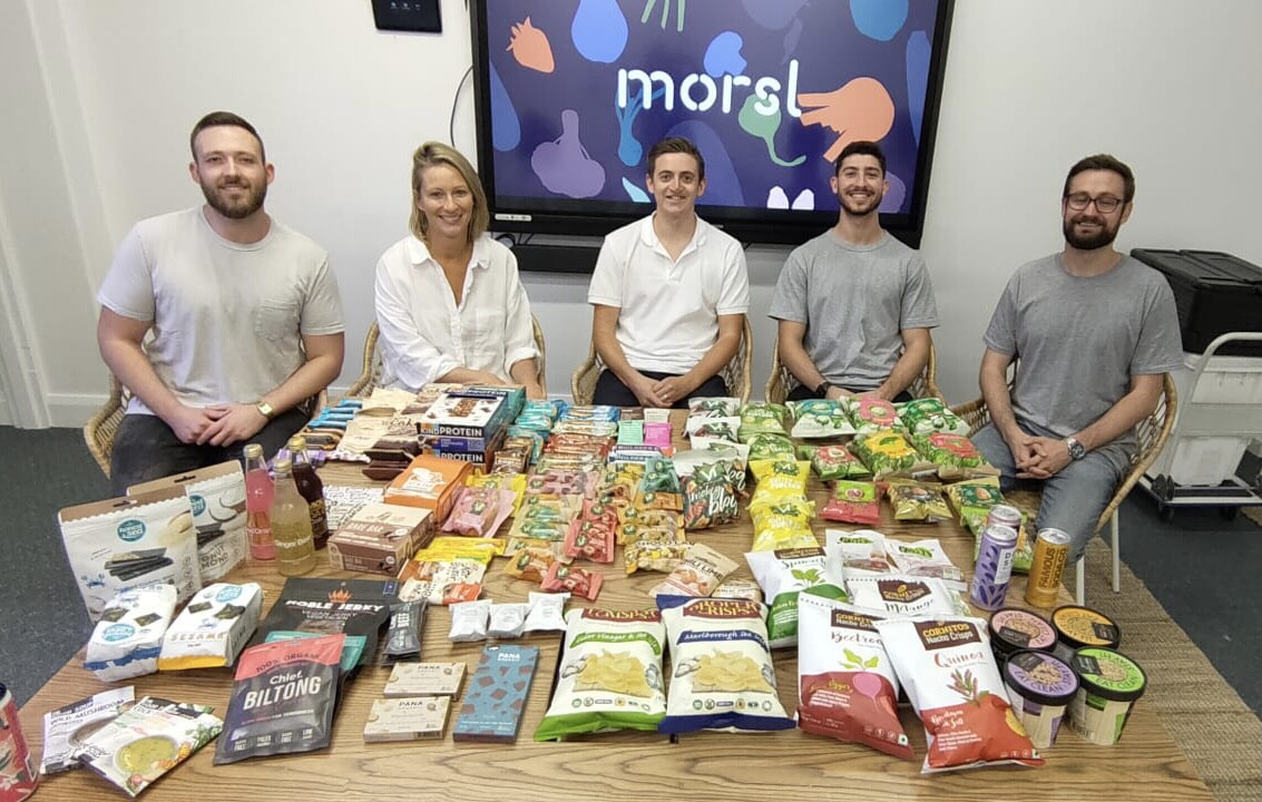 Karla Borland, second from left, seated with four members of the Morsl team behind a table of food products.