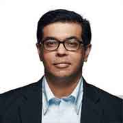 An earlier professional portrait of Kartik Murugan