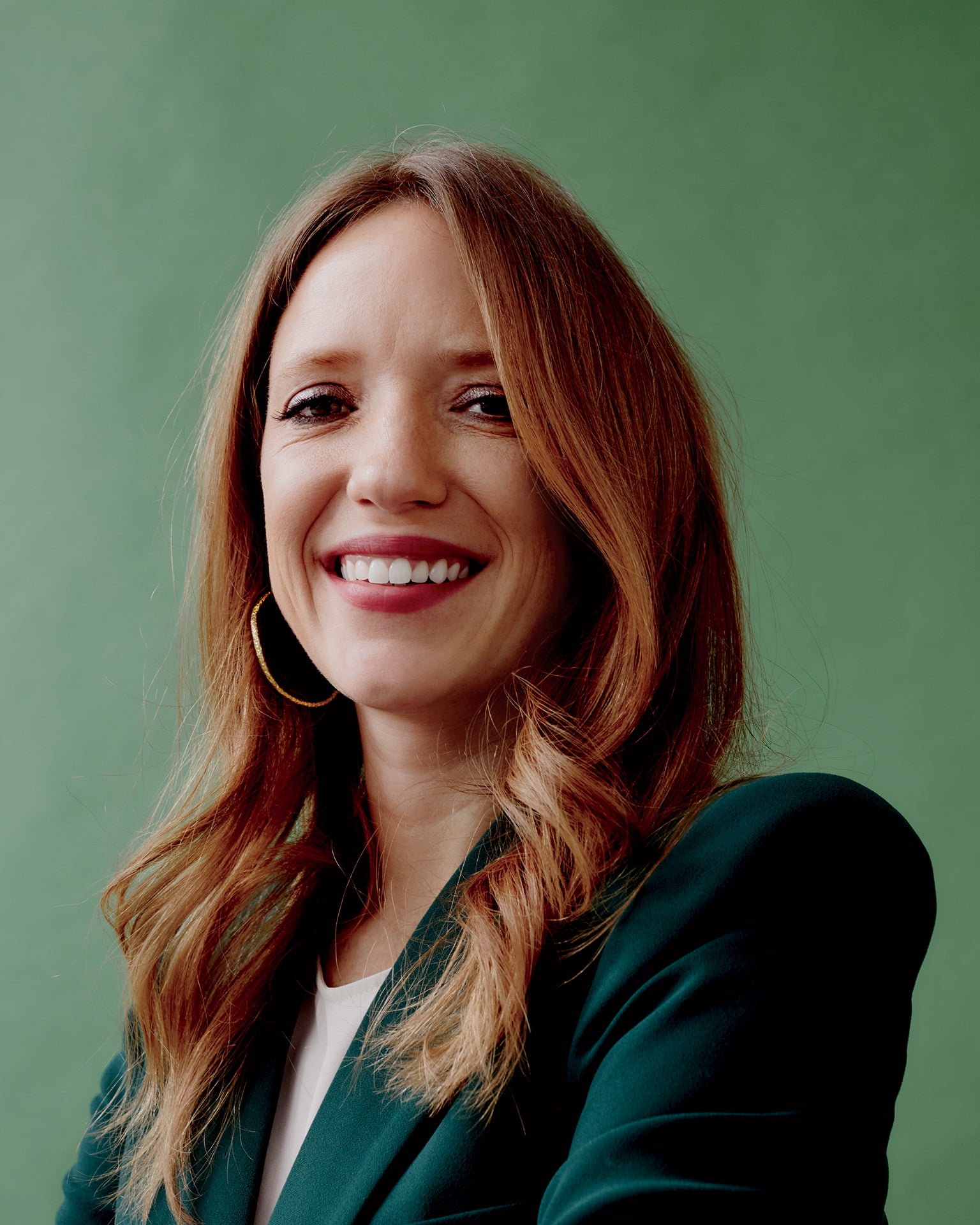 Kate Ryder smiling against a green studio background