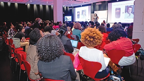 Kathryn Finney speaks from the front of a crowded FOCUS100 conference room in 2013