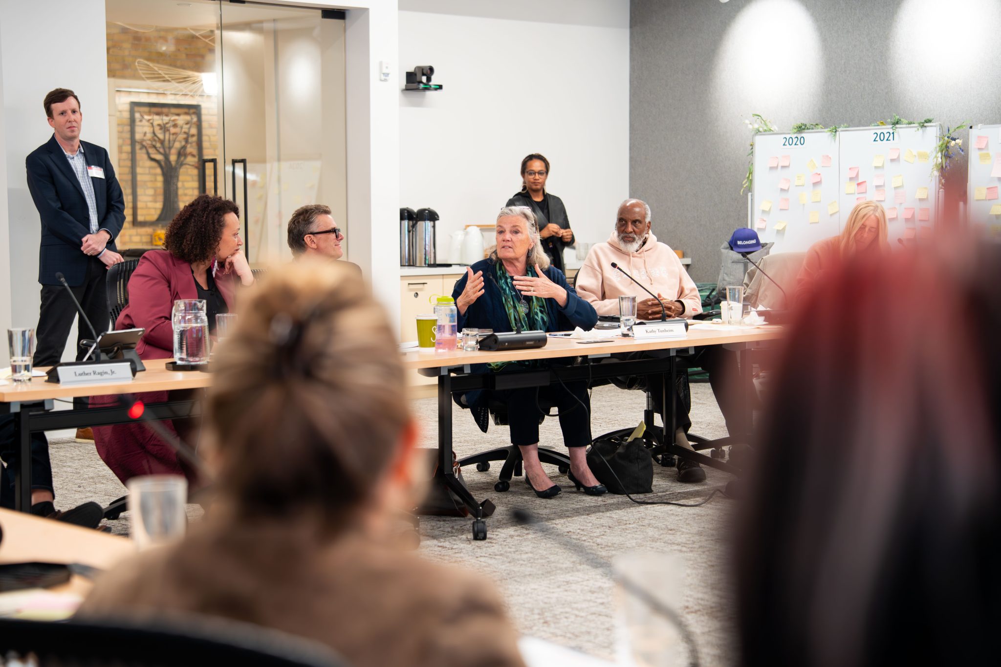 Kathy Tunheim, seated at the center of a table, speaking with McKnight Foundation board and staff members