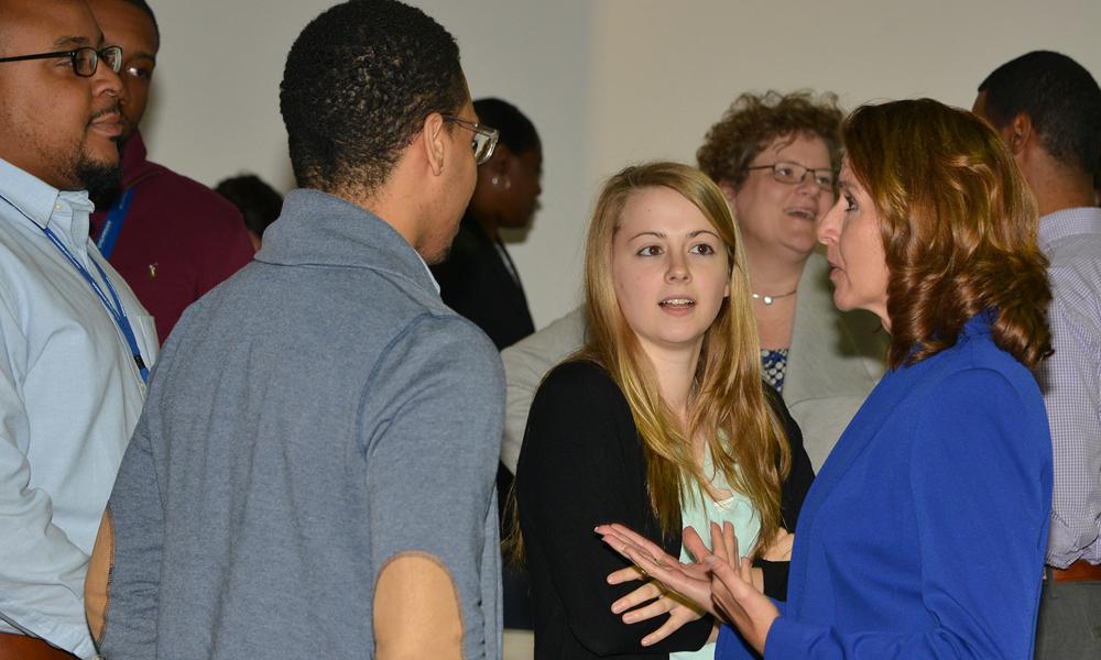 Kathy Warden, at right in blue, talks with early-career employees after a town hall.