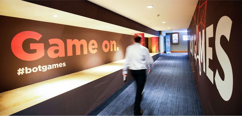An attendee walks through a corridor wrapped in Automation Anywhere Bot Games event graphics