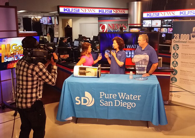 A Pure Water demonstration with a pitcher and filtration display on a KUSI television set.