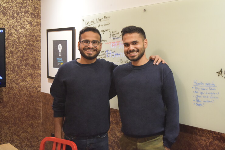 Kaushik Tiwari and Saumik Tiwari standing beside a whiteboard in an office
