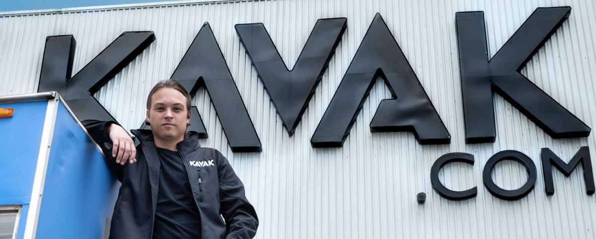 Carlos García Ottati beside the large Kavak lettering on a building