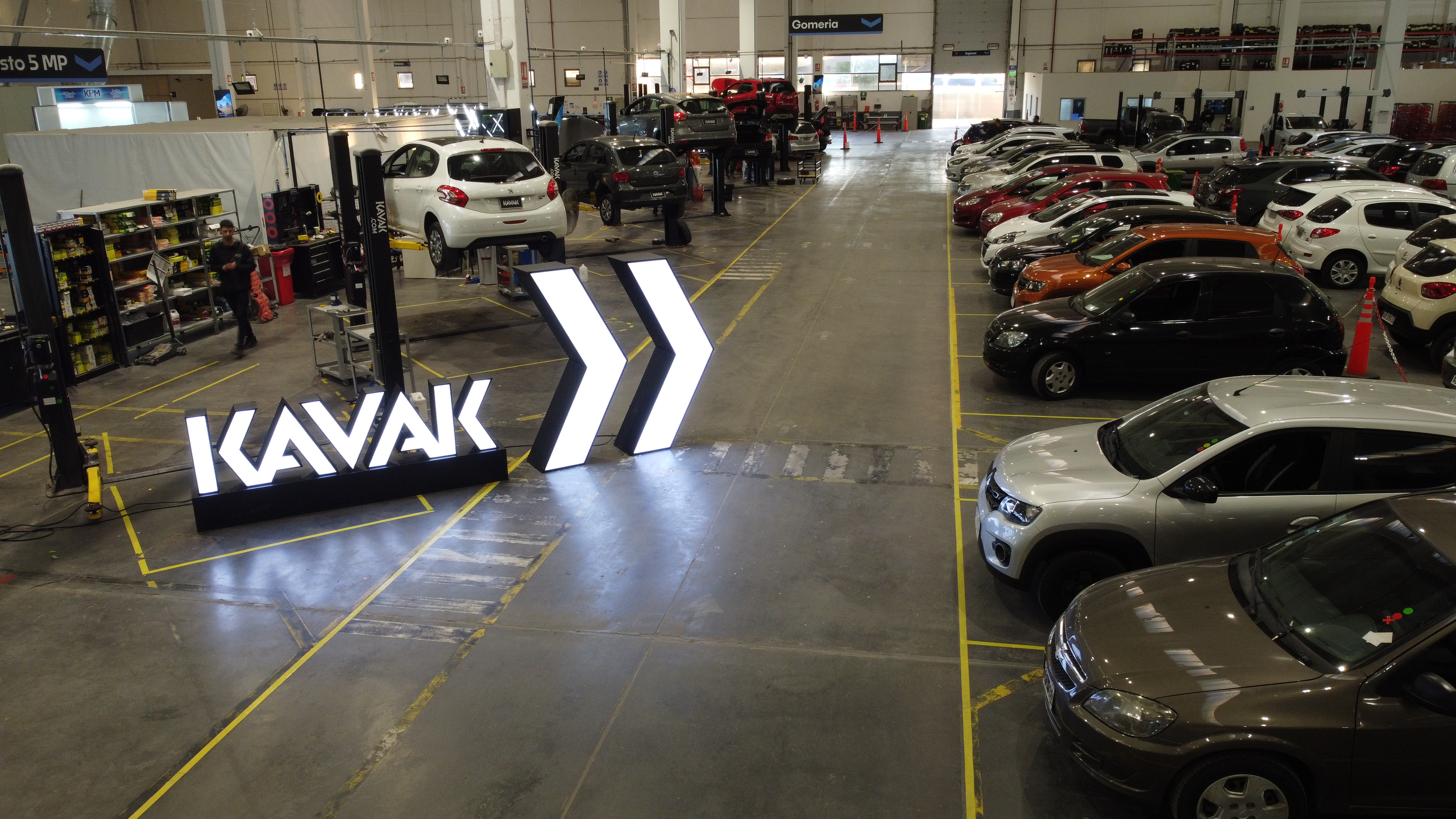 Rows of used cars and vehicle lifts inside Kavak’s Tigre reconditioning workshop in Argentina
