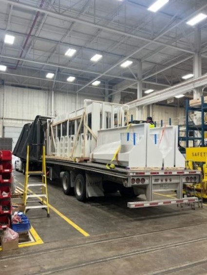 Industrial equipment being loaded on a trailer inside a factory