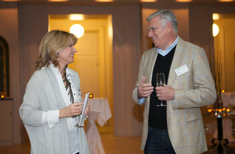Meg Touborg and Keith Granet smiling during a conversation at a gathering
