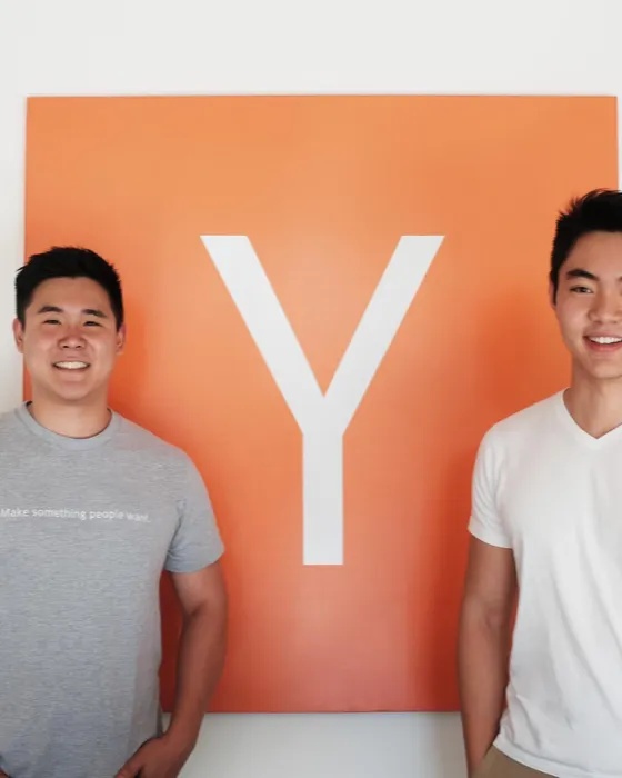 Keith Ryu, left, and co-founder Jeremy Cai in front of a Y Combinator sign