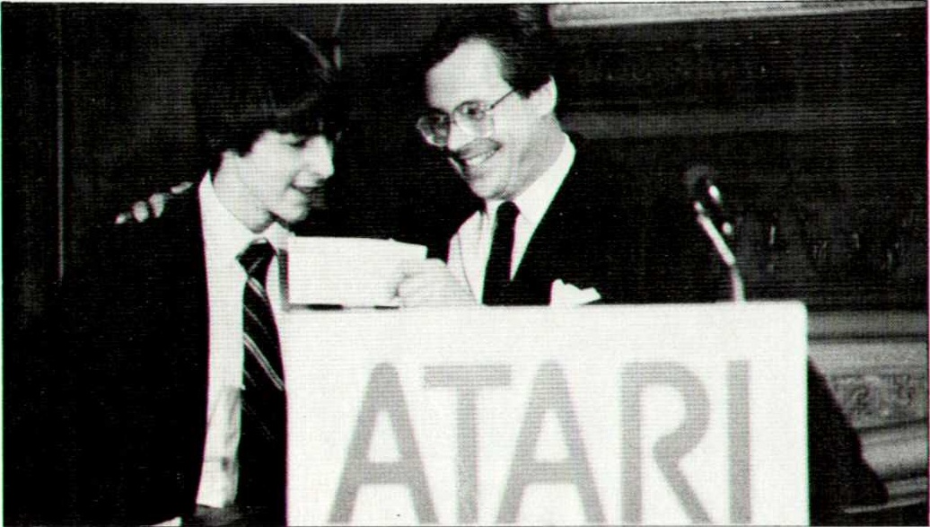 David Buehler, left, receives his Atari award cheque from Keith Schaefer in 1983