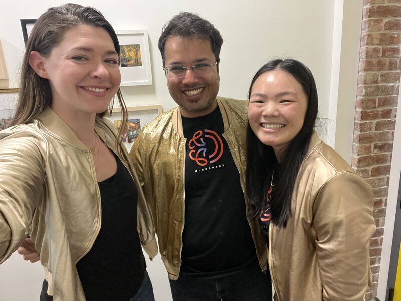 Kelly Cheng smiling with Goldcast colleagues in matching gold jackets