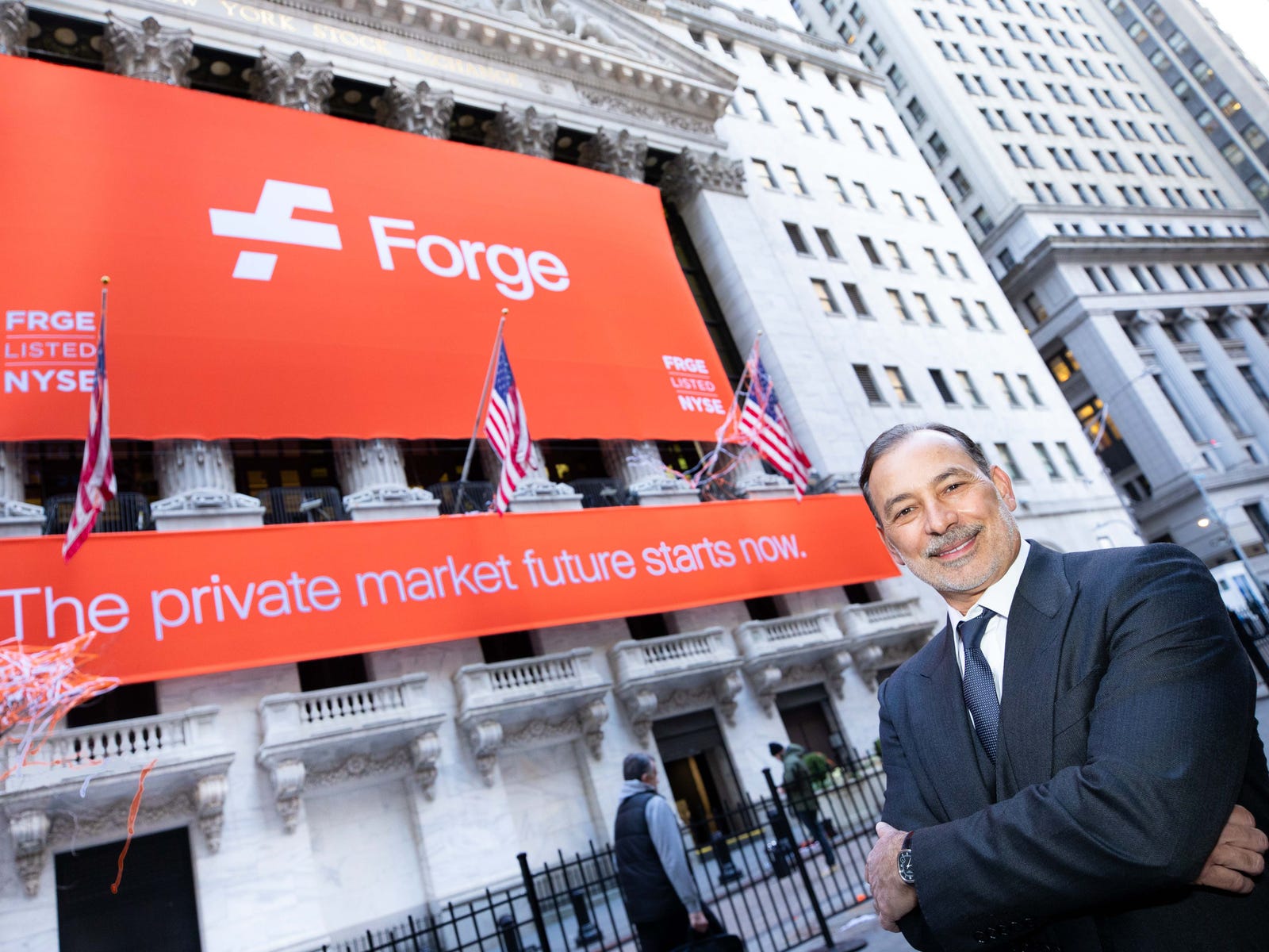 Kelly Rodriques outside the New York Stock Exchange beneath an orange Forge banner