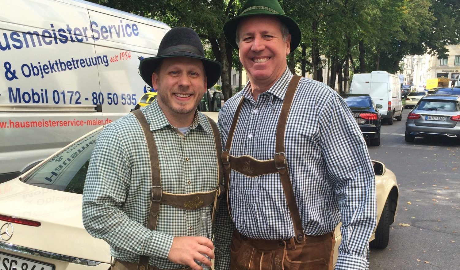 Ken Beam, right, and a companion wearing checked shirts, hats and traditional Alpine-style clothing outdoors