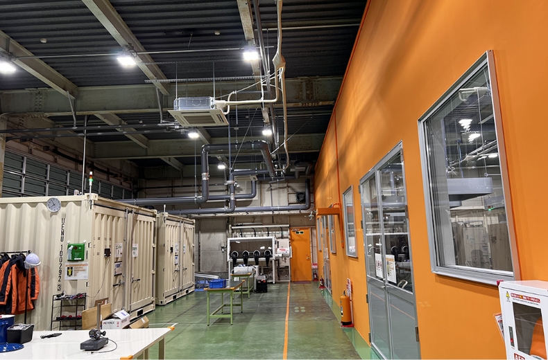 Industrial workspace pictured in Ken Ogata’s Japan Venture Awards interview, with test enclosures, pipes and an orange-walled room