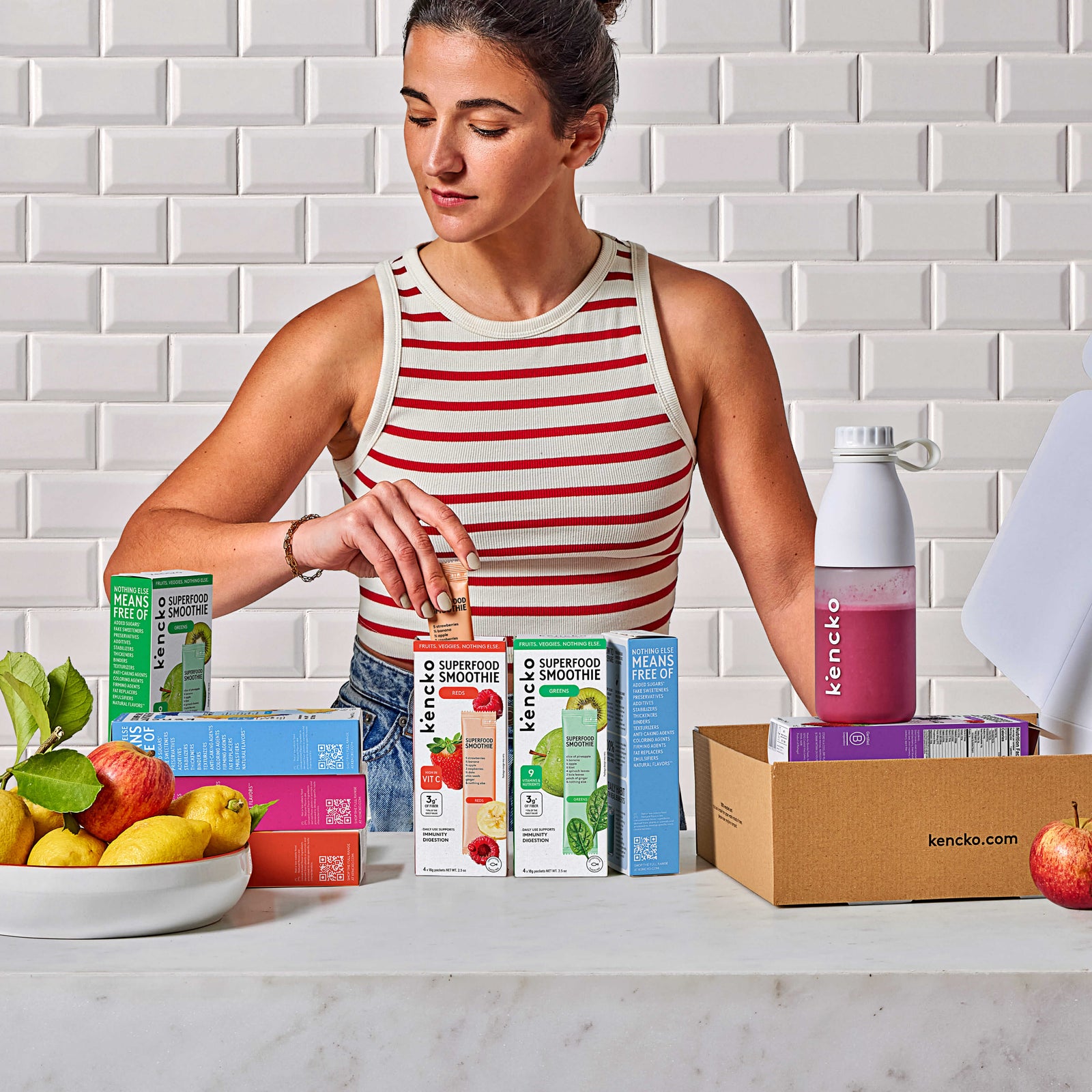 A customer selects a kencko smoothie sachet beside colorful retail packs and a mixer bottle