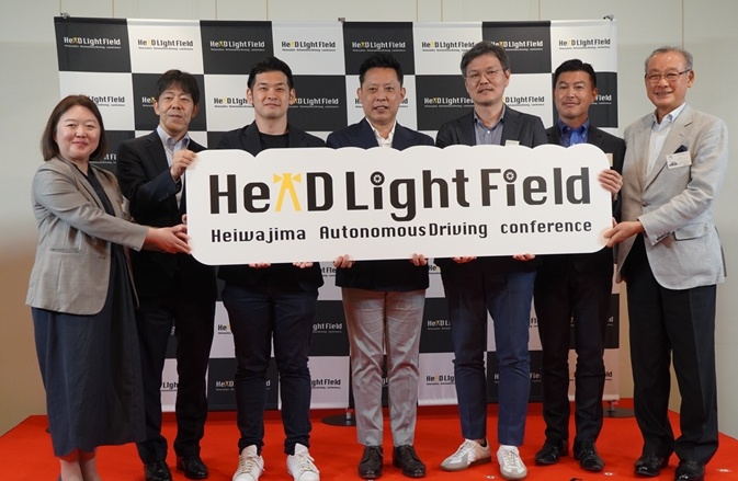 Seven representatives holding the Heiwajima autonomous driving council sign; Kenji Nakashima stands fourth from the left