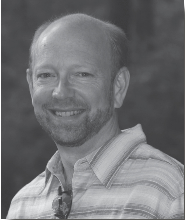 Archival black-and-white photograph of Ken deLaski in a striped shirt, published in River Watch in 2008.