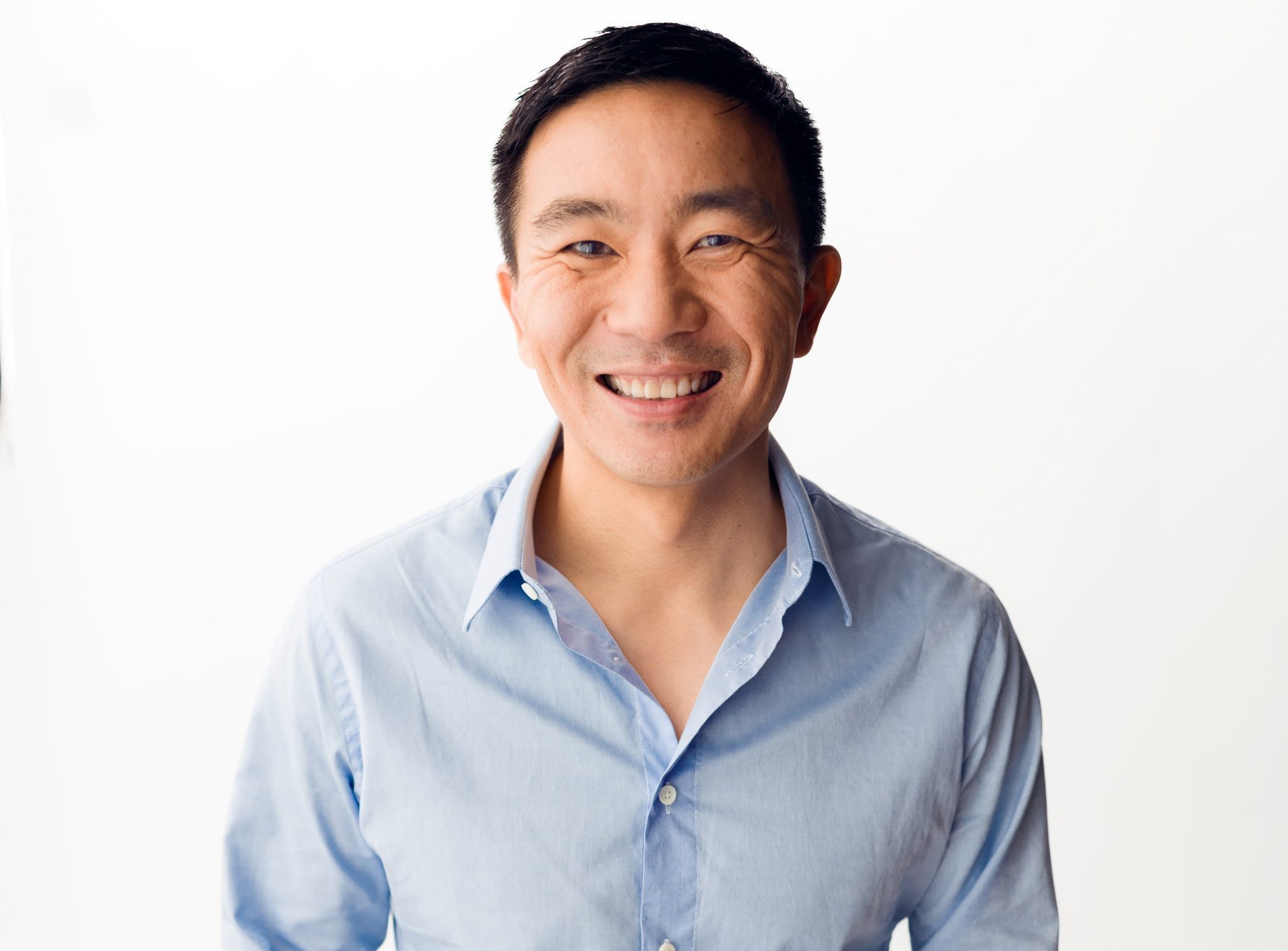 Kenneth Lin smiling in a light blue shirt in a Credit Karma press photograph