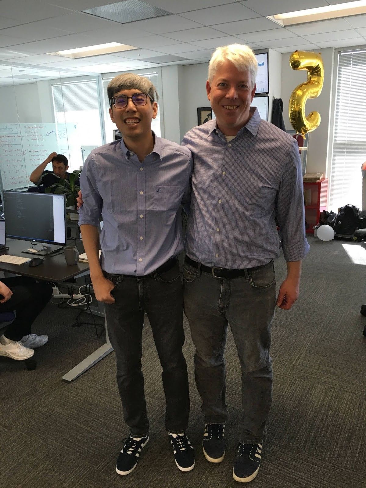 Kenneth Truong standing beside Sigma co-founder Rob Woollen in matching shirts during an office birthday prank