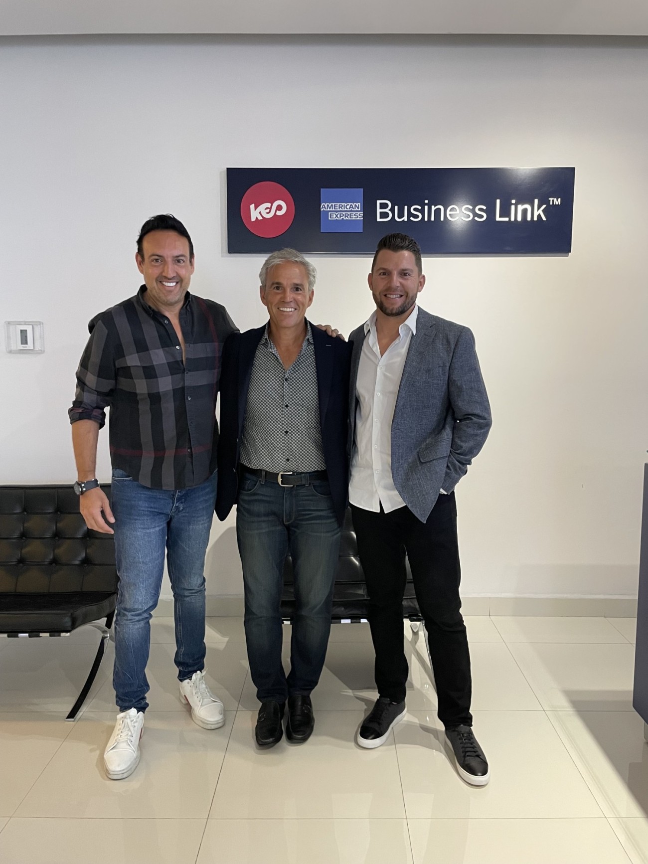 Paolo Fidanza with Next Sparc investors Len Pagon Jr. and James Carey beneath a KEO and American Express Business Link sign