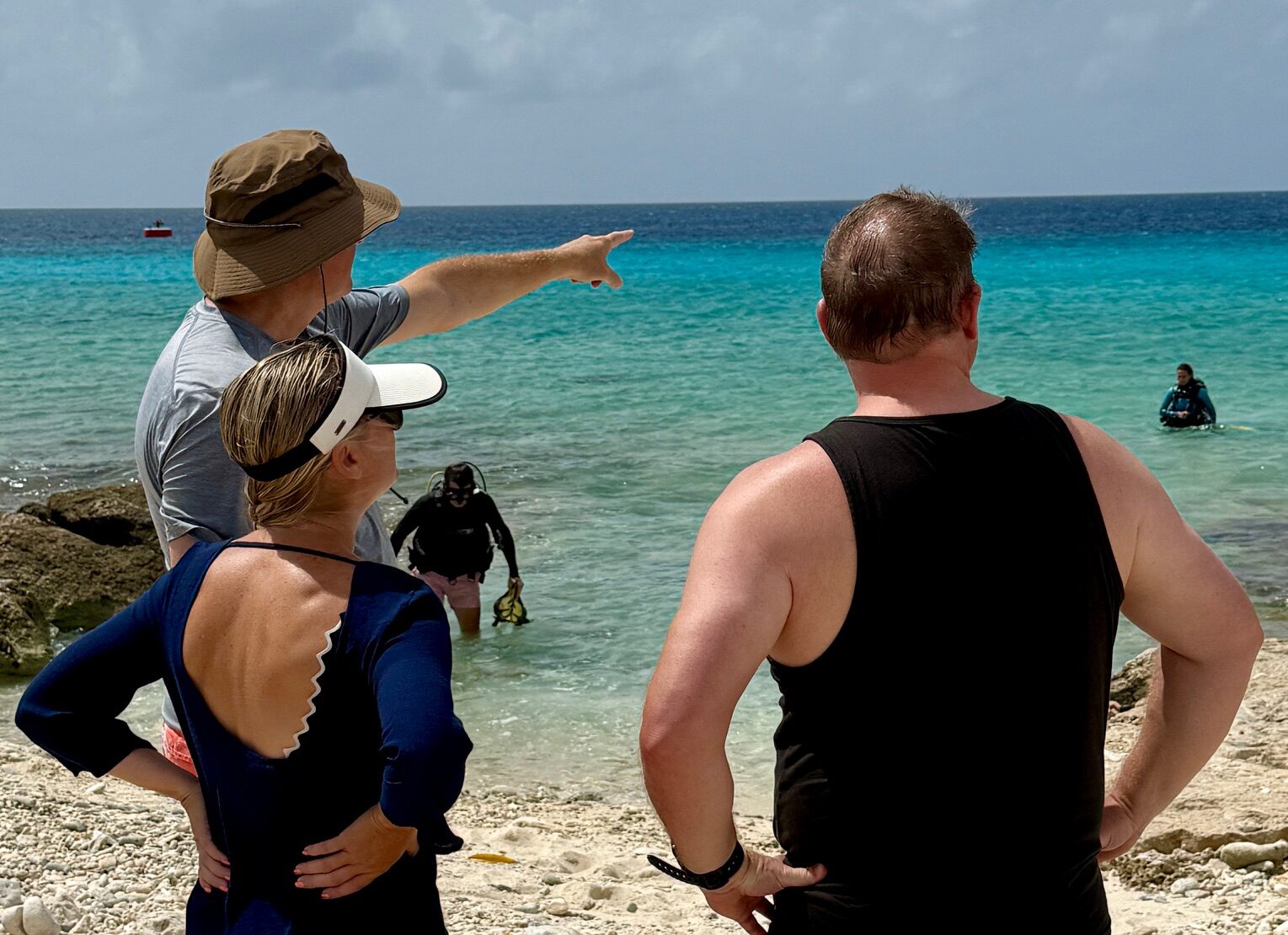 Kerry Frank and companions standing beside clear blue water