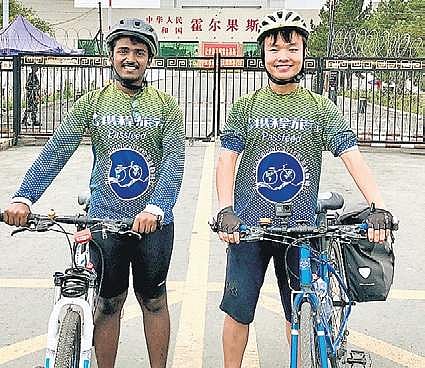 Kesava Kirupa Dinakaran, left, and Jerry Huang standing with their bicycles during their Silk Road journey