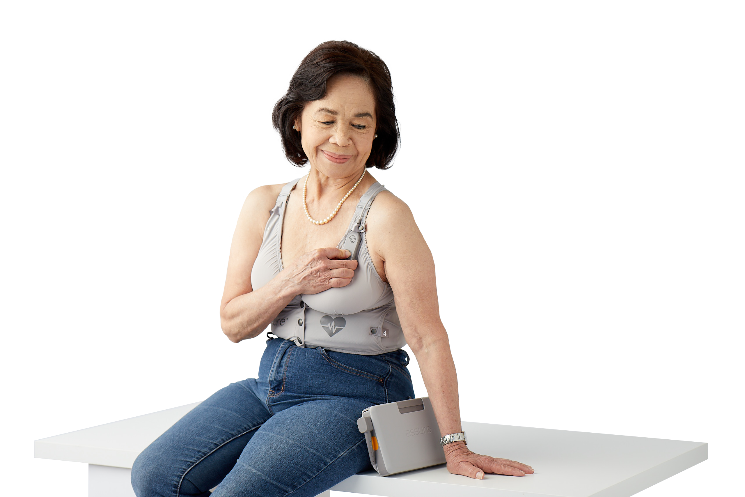 Kestra promotional photograph showing a seated woman wearing the ASSURE SensorFit garment and monitor