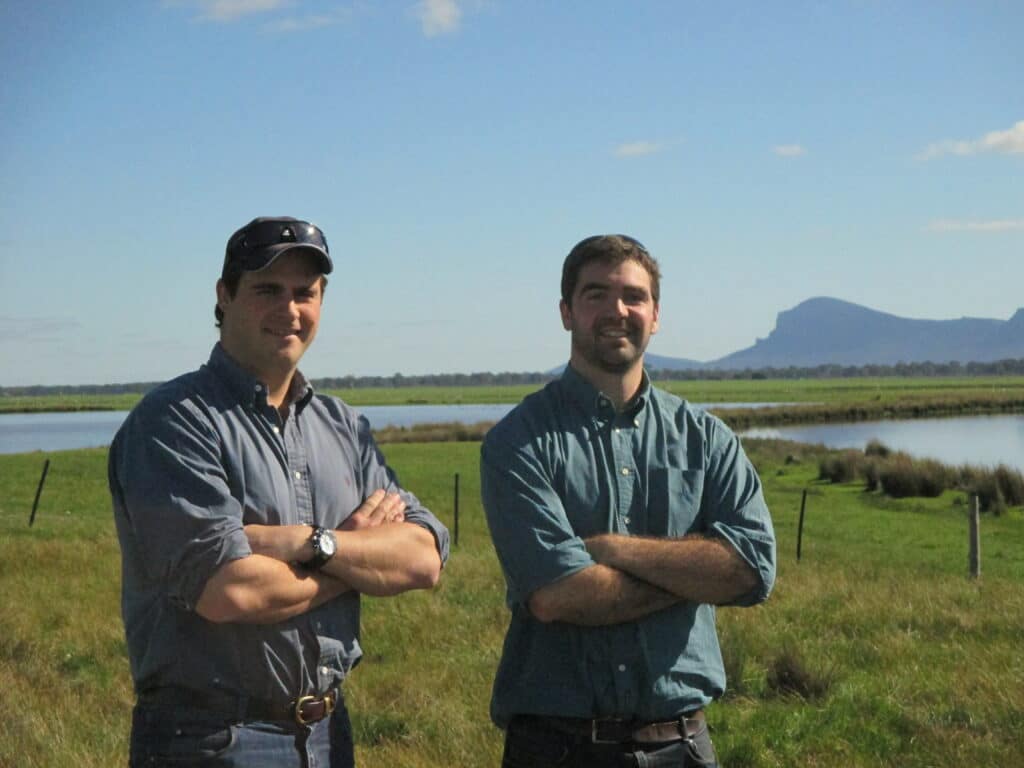 AgriWebb co-founders Justin Webb and Kevin Baum standing together on an Australian farm