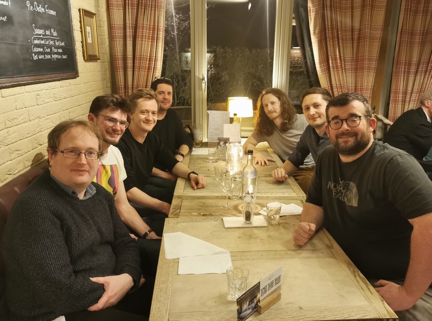 The seven members of Gearset’s original founding team seated around a restaurant table