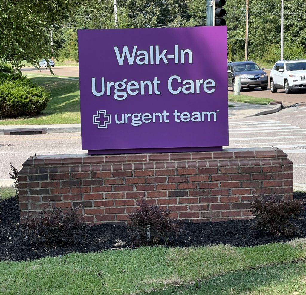 Purple Urgent Team walk-in urgent care sign beside a road