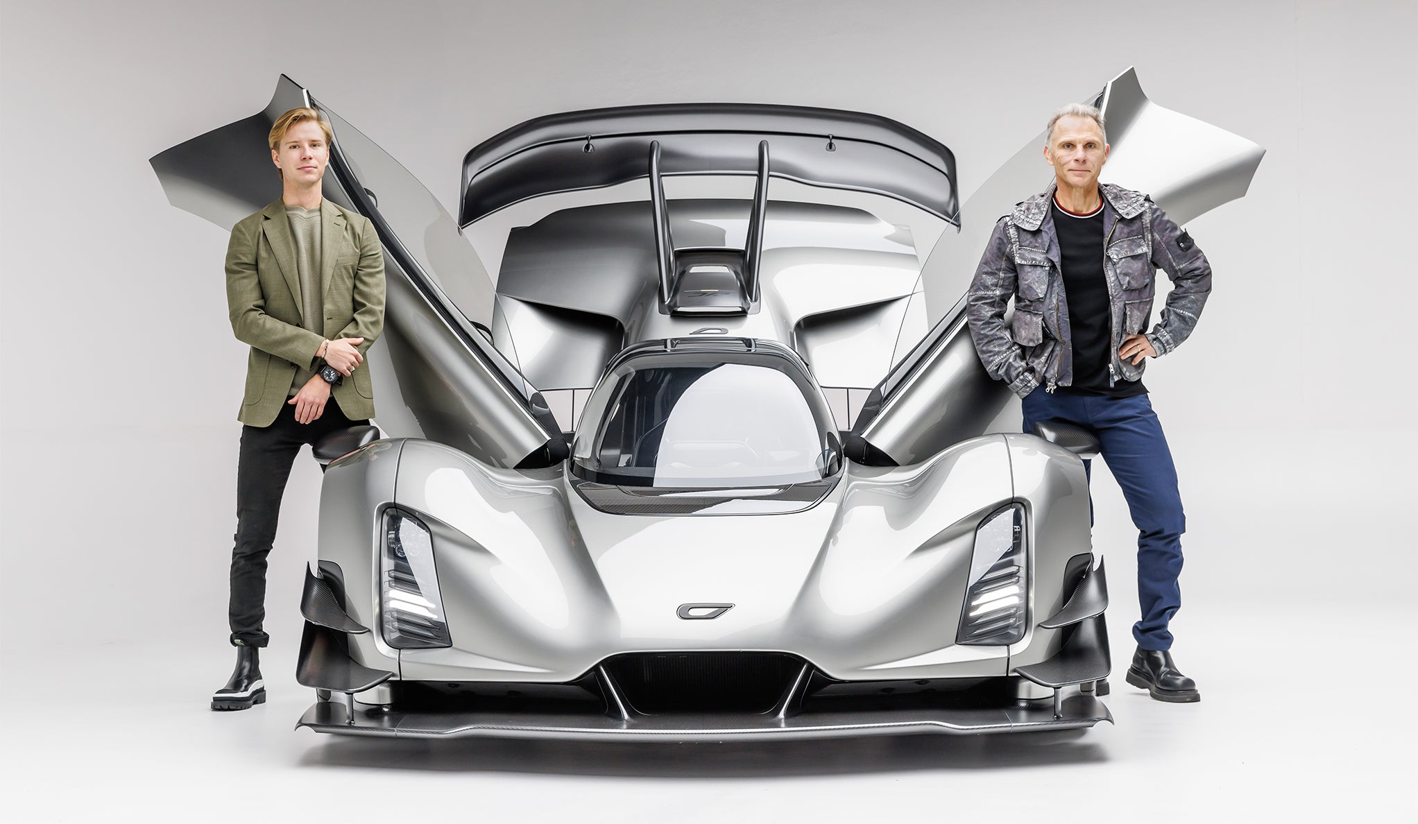 Lukas Czinger on the left and Kevin Czinger on the right, standing beside a silver Czinger 21C with its doors raised