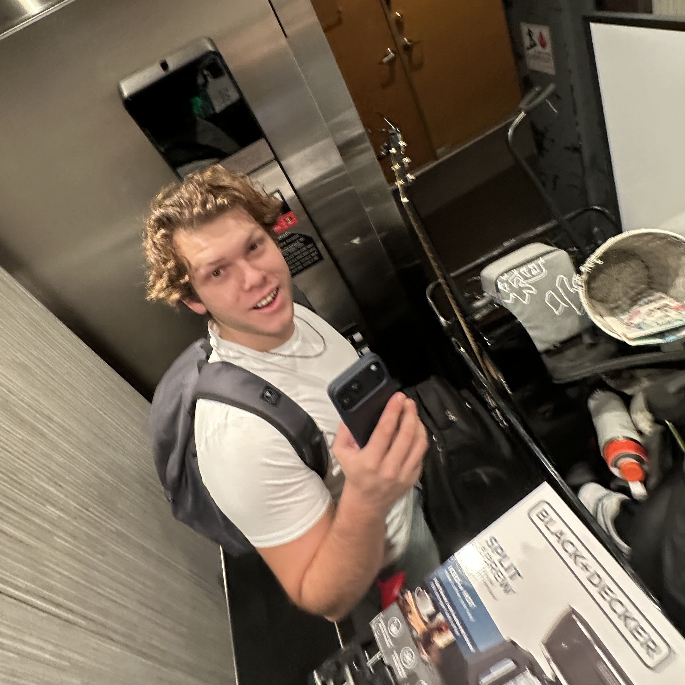 Kevin Figueroa smiling in an elevator crowded with moving boxes