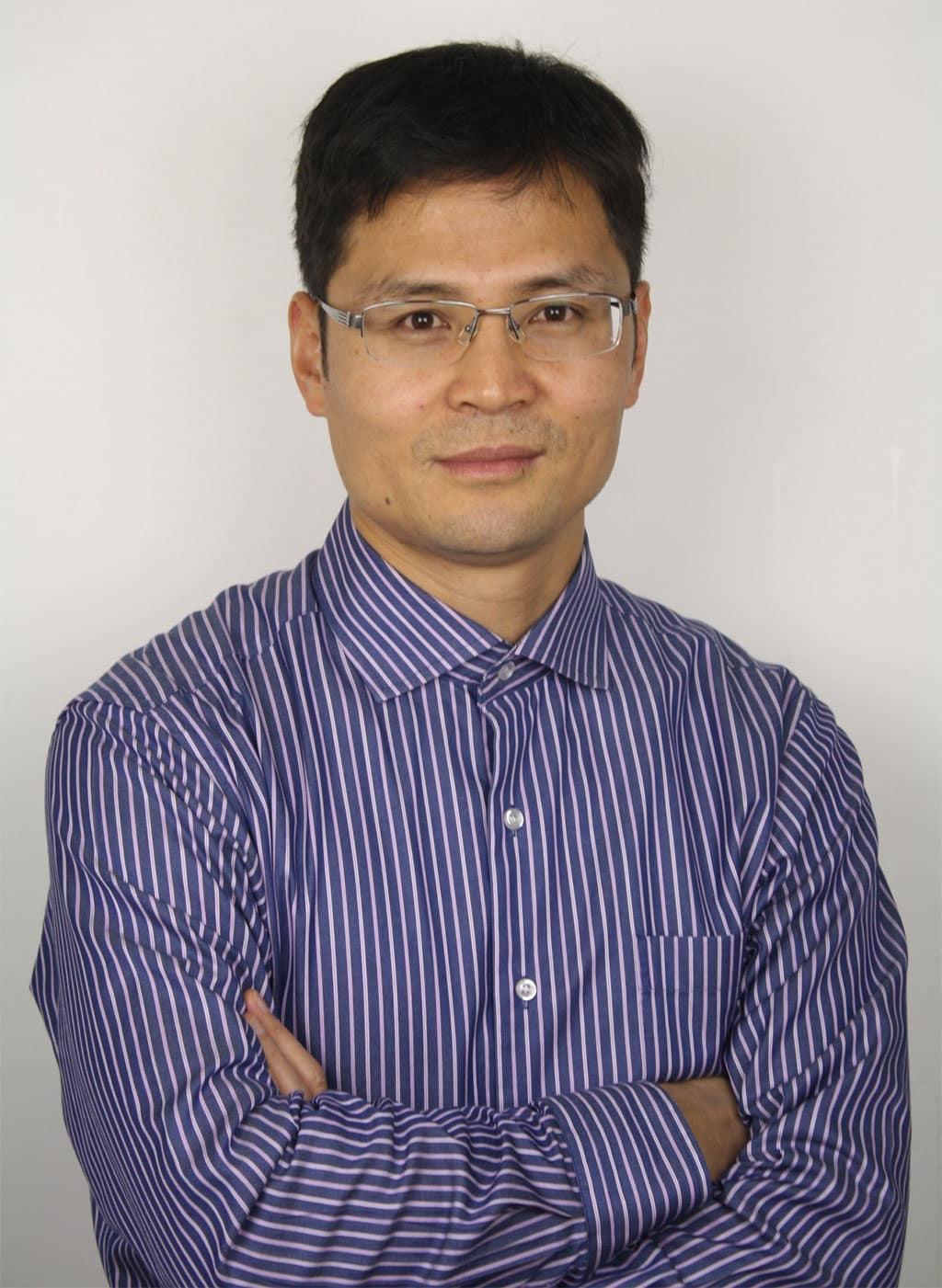Kevin Gao in glasses and a striped shirt, arms folded