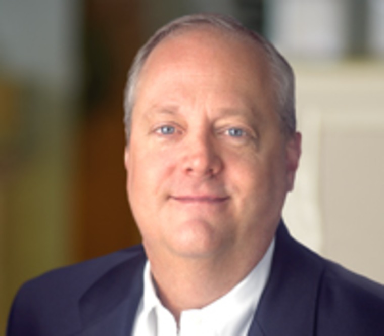 Kevin Leininger in a dark jacket and open-collar white shirt