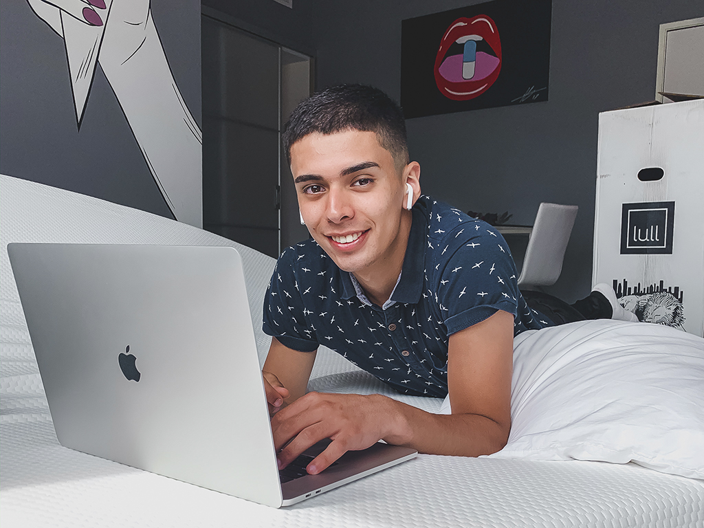 A young Kevin Leyes working on a laptop in a bedroom