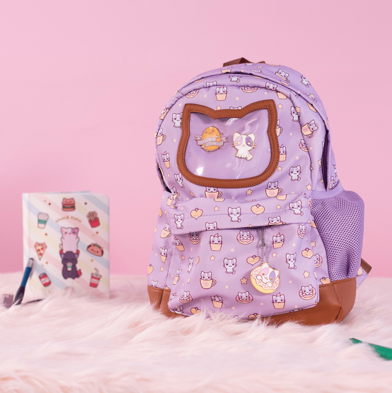 A lavender creator-branded backpack photographed against a pink background