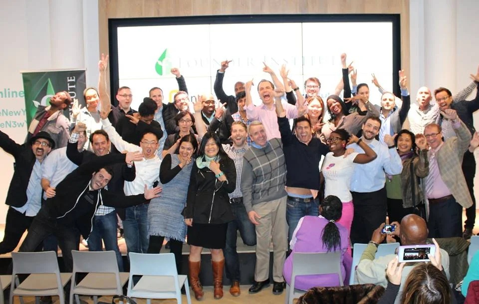Kevin Siskar with a lively group of Founder Institute graduates, posing with raised hands