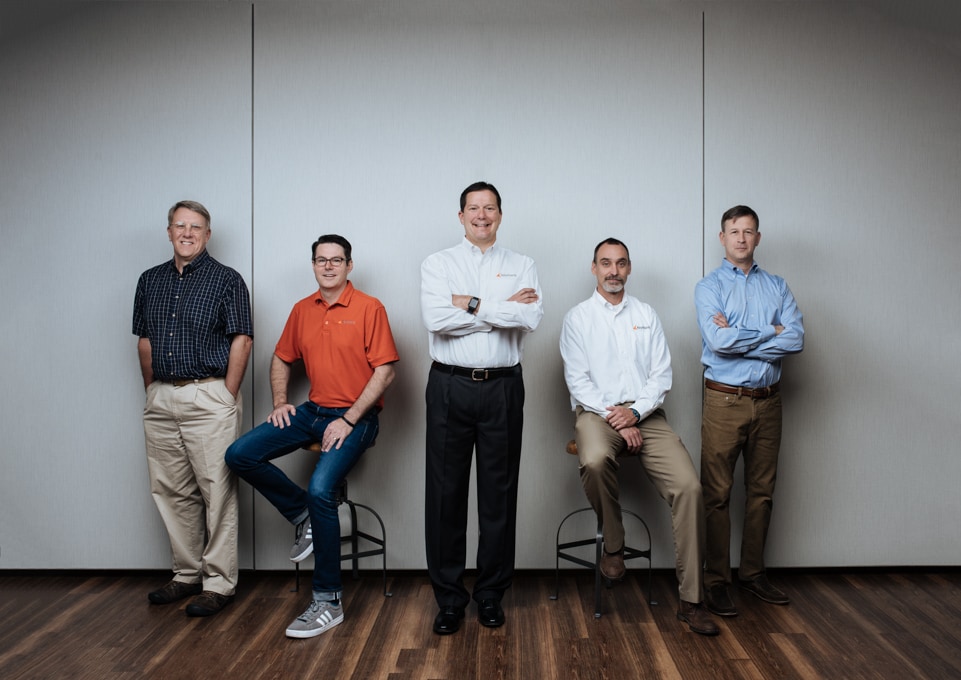 Five KeyMark executives pose for a 2018 team portrait, with founder Jim Wanner in the center.