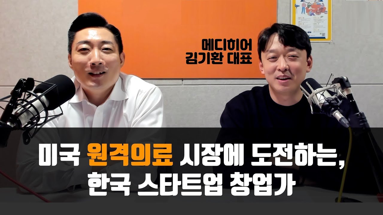 Kihwan Kim, right, speaking during a 2021 video interview with two microphones on the desk