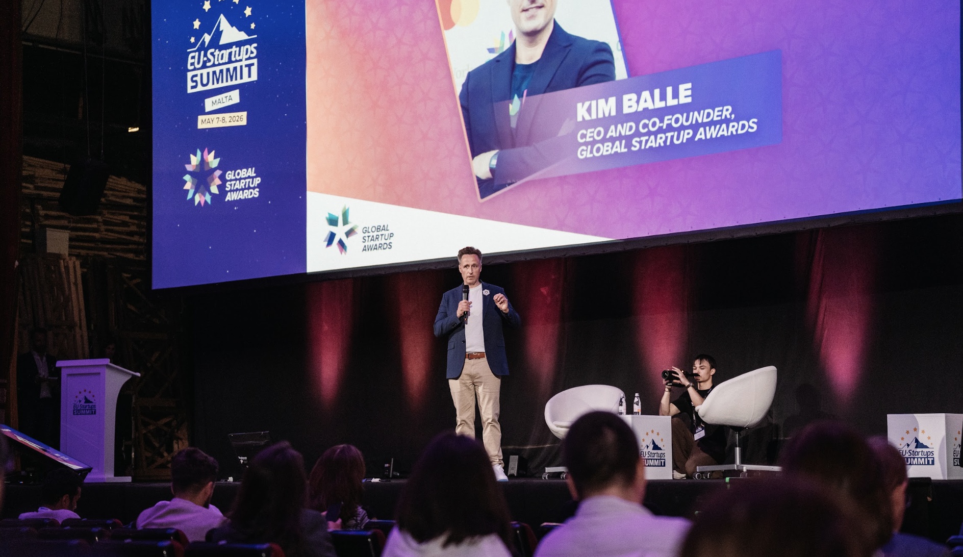 Kim Balle speaking on stage at the 2026 EU-Startups Summit, with his name projected behind him