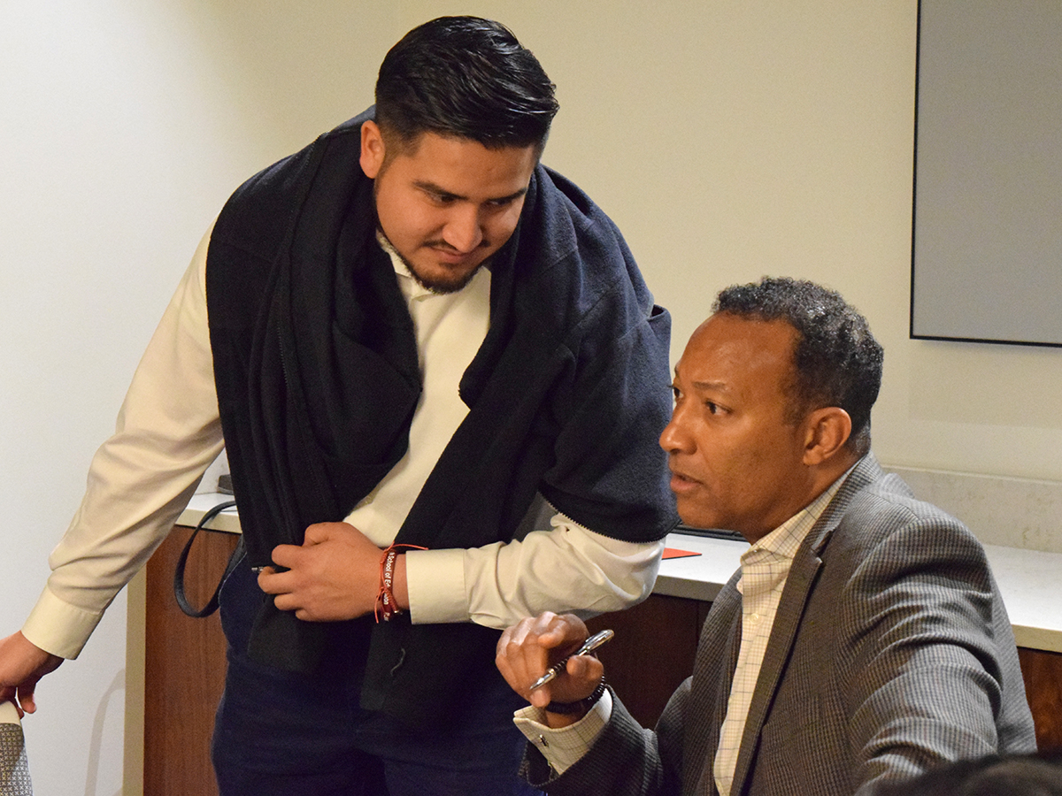 Kim L. Hunter, seated at right, speaks with a student during his visit to Elon University.