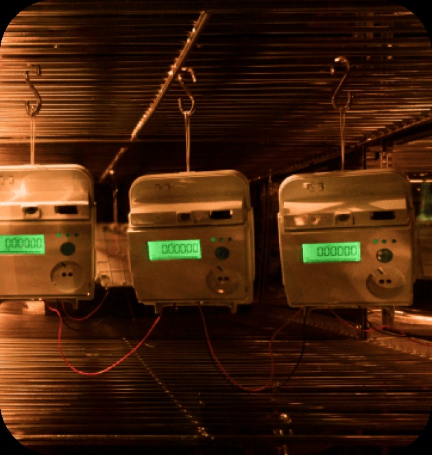Three electricity meters undergoing testing inside a chamber at Kimbal’s manufacturing facility