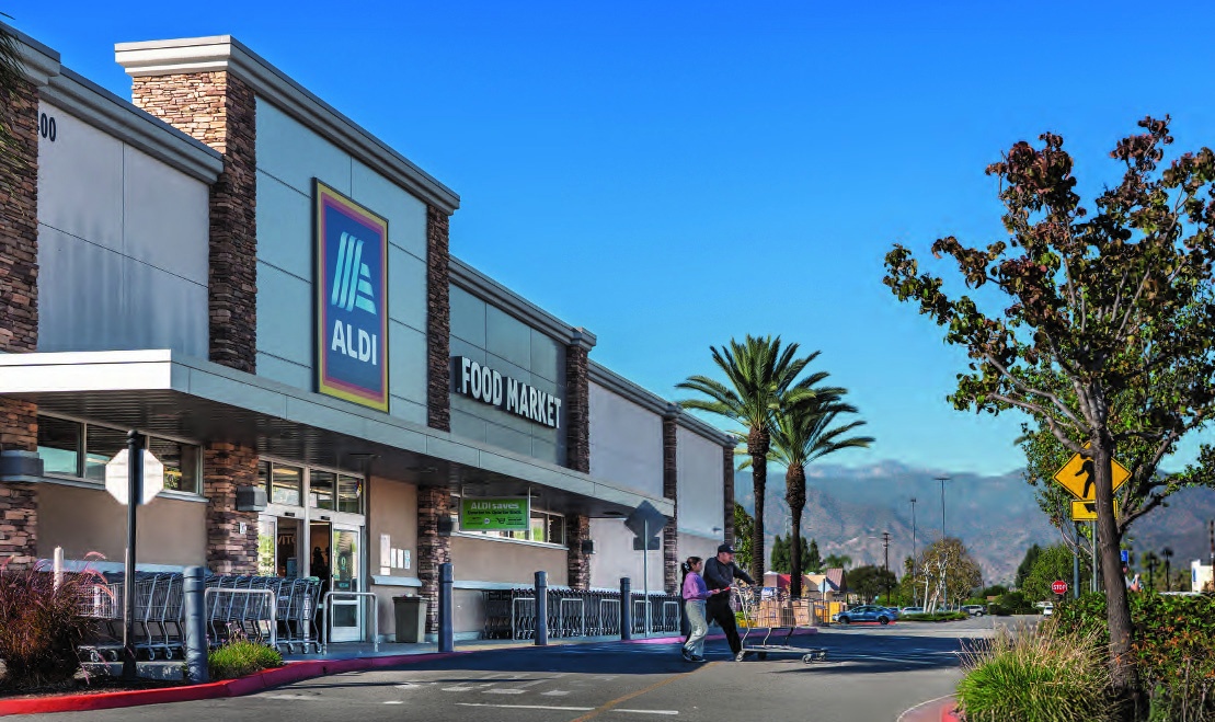 An ALDI storefront at Covina Town Square, with palm trees and mountains beyond the shopping center.