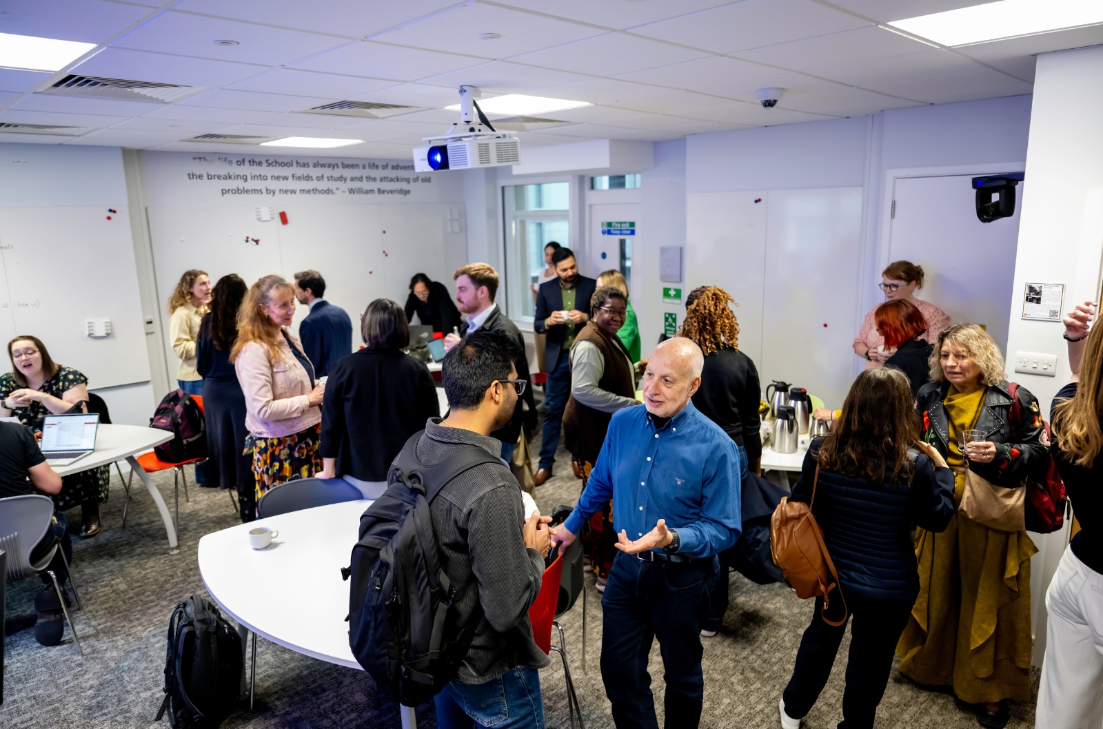 Researchers and professional staff talking in small groups at a Kindling workshop