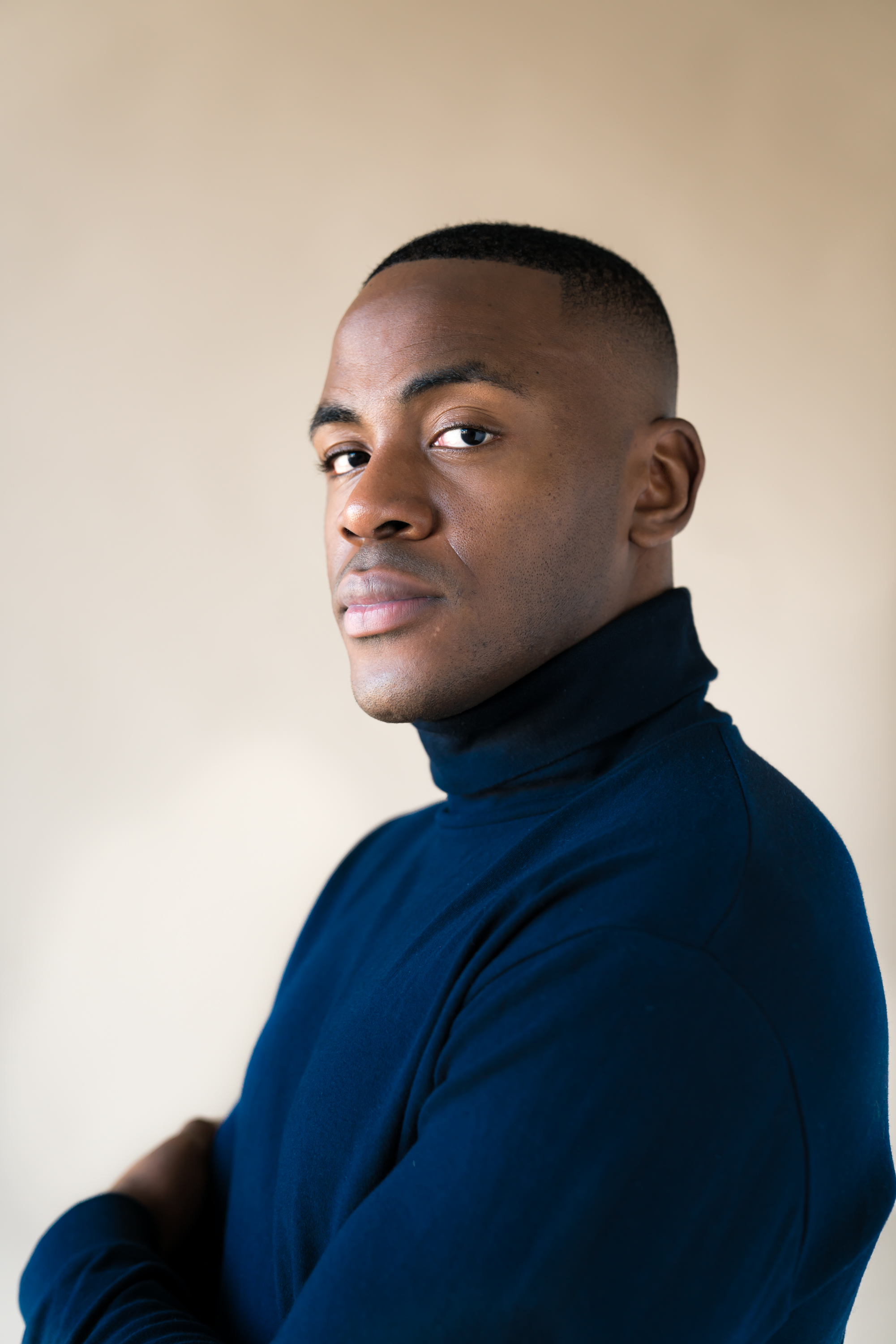 King Nnamani in a dark roll-neck portrait